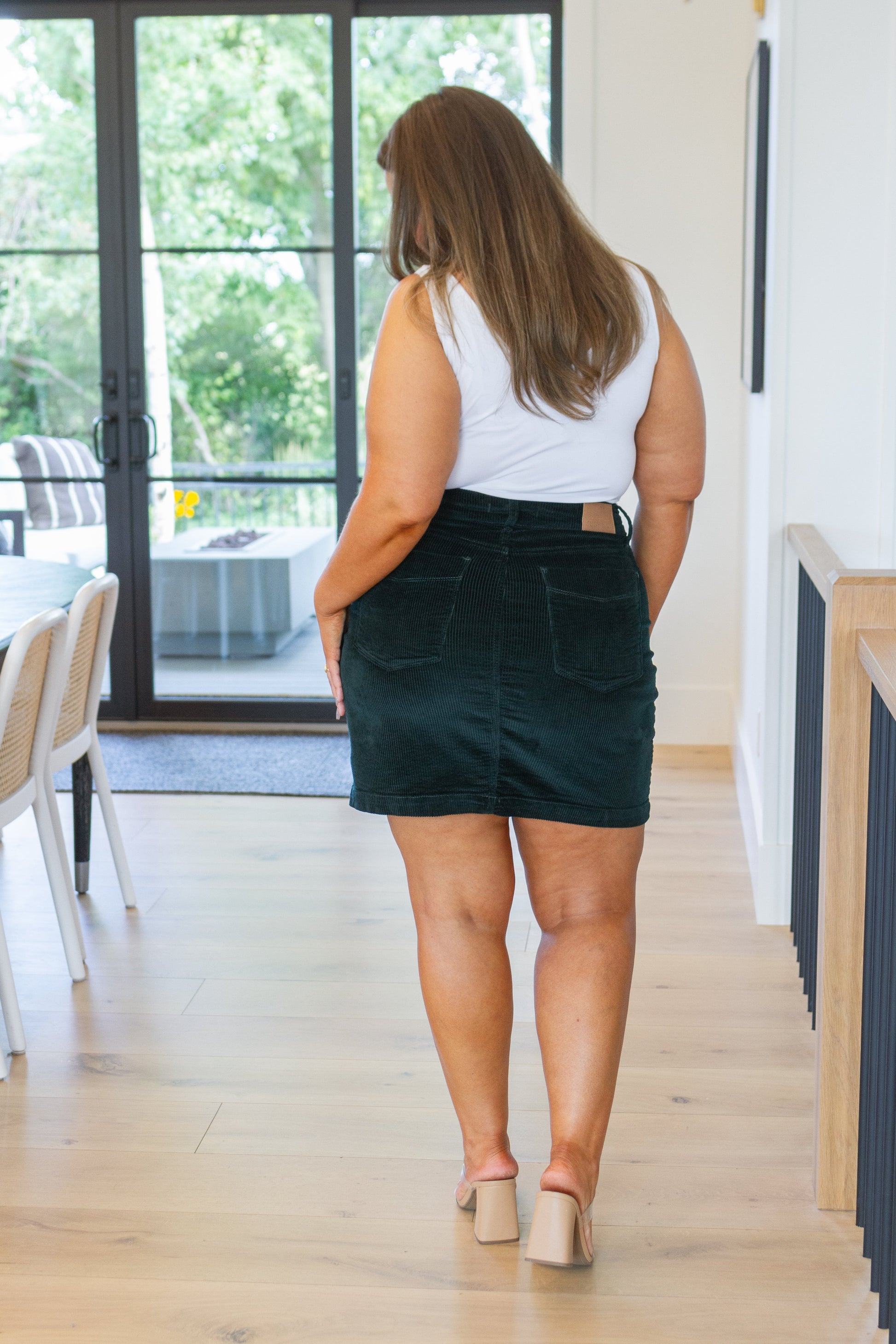 Emerald corduroy high-rise mini skirt with patch pockets, button closure, and zip fly. Casual style.