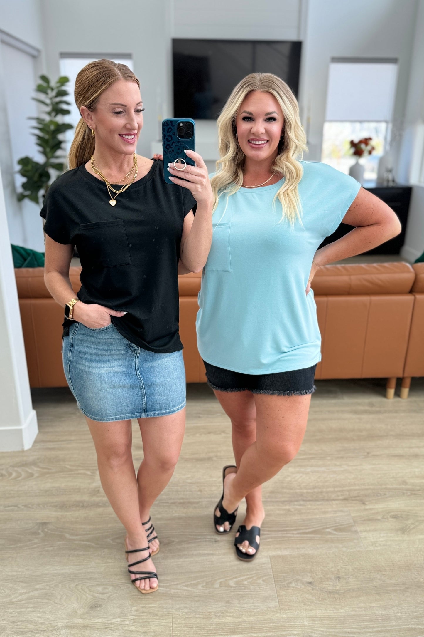 Two models wearing Briar Pocket Tee in blue; one styled with denim skirt, the other with shorts, showing dolman sleeves and pocket.