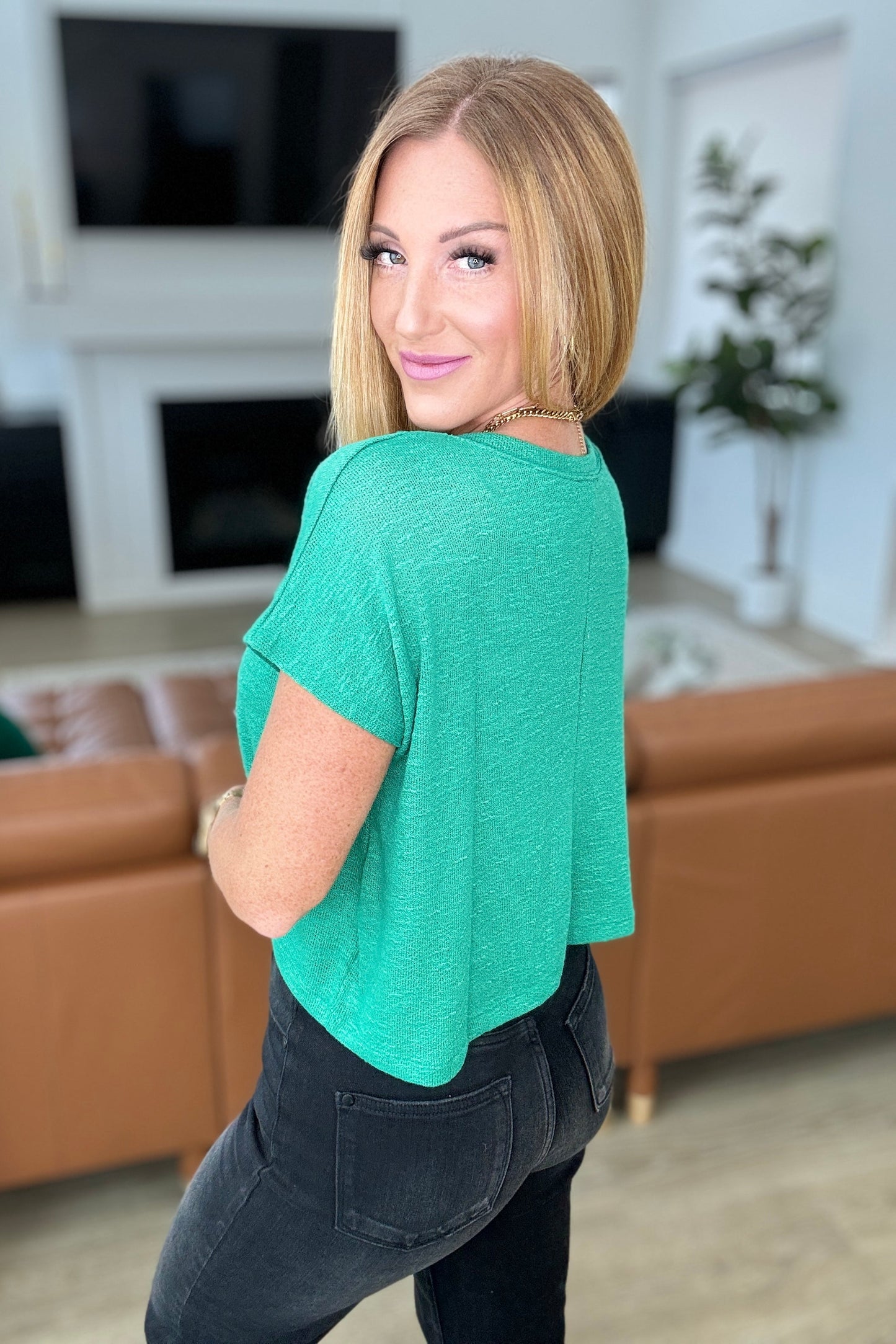 Kelly green cropped V-neck top made of lightweight jersey knit, featuring a banded neckline and short dolman sleeves