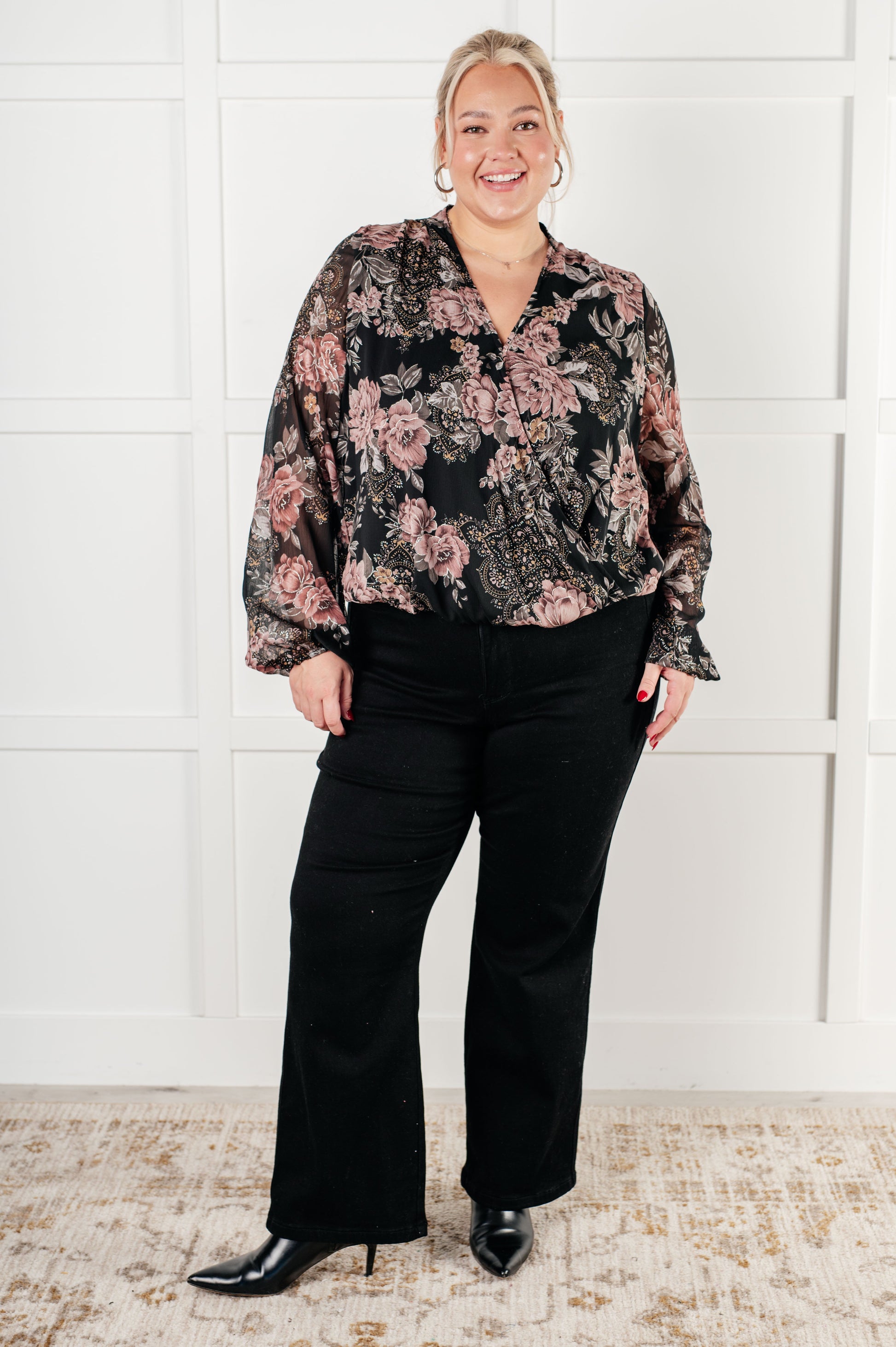 Plus Size women's v-neck floral blouse in black chiffon with floral print, featuring a v-neckline, surplice bodice with hook and eye closure, long balloon sleeves with cased elastic cuffs, and scooped hemline with cased elastic front hemline. Lined bodice.