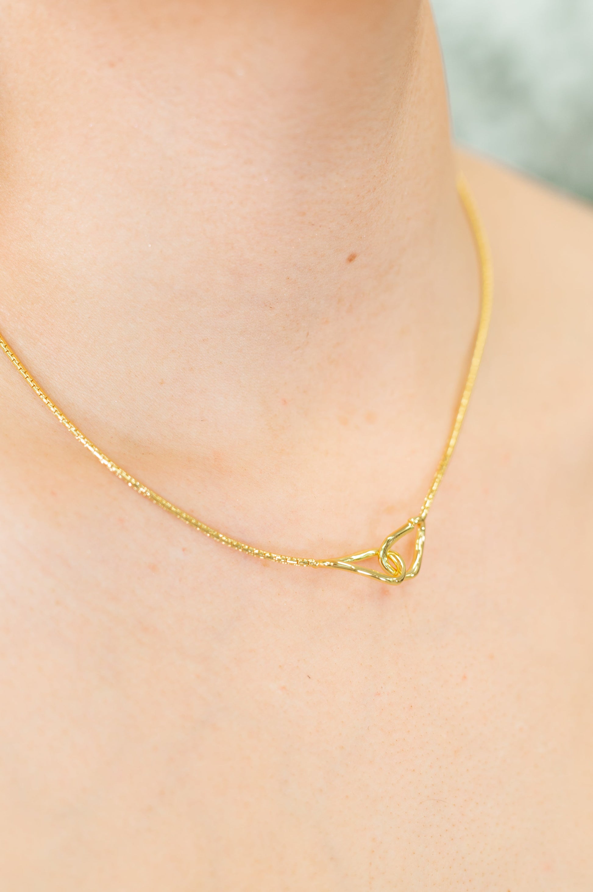 Woman wearing the I’ve Got You Necklace, showcasing the gold-plated chain with pendant and hoop closure.