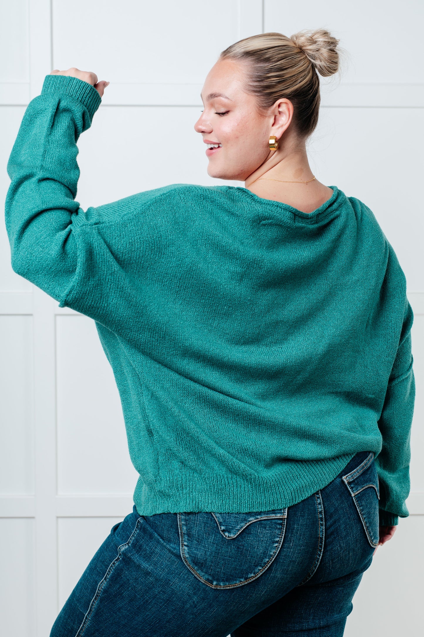 Teal women's sweater featuring a ribbed exposed seam boat neckline, long drop-shoulder sleeves, exposed seam, ribbed cuffs and hemline, and a chest pocket.