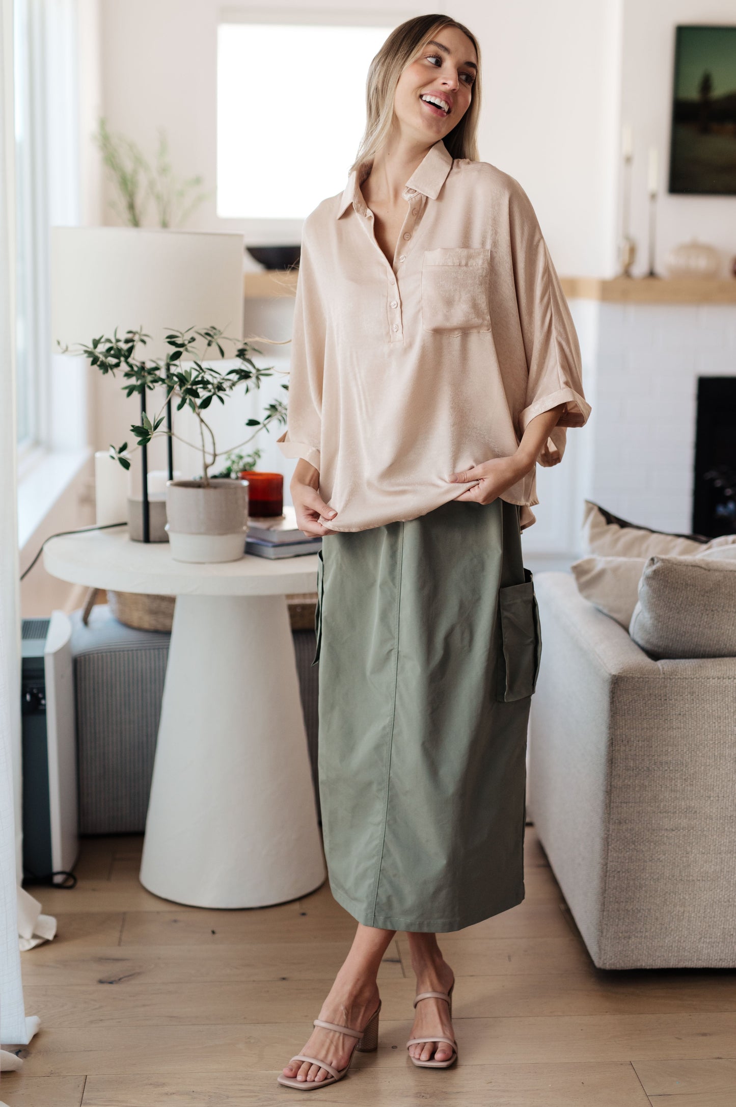 Champagne-colored poly satin top with a collared neckline, quarter-length button placket, oversized dolman sleeves with rolled cuffs, and a boxy, oversized fit.