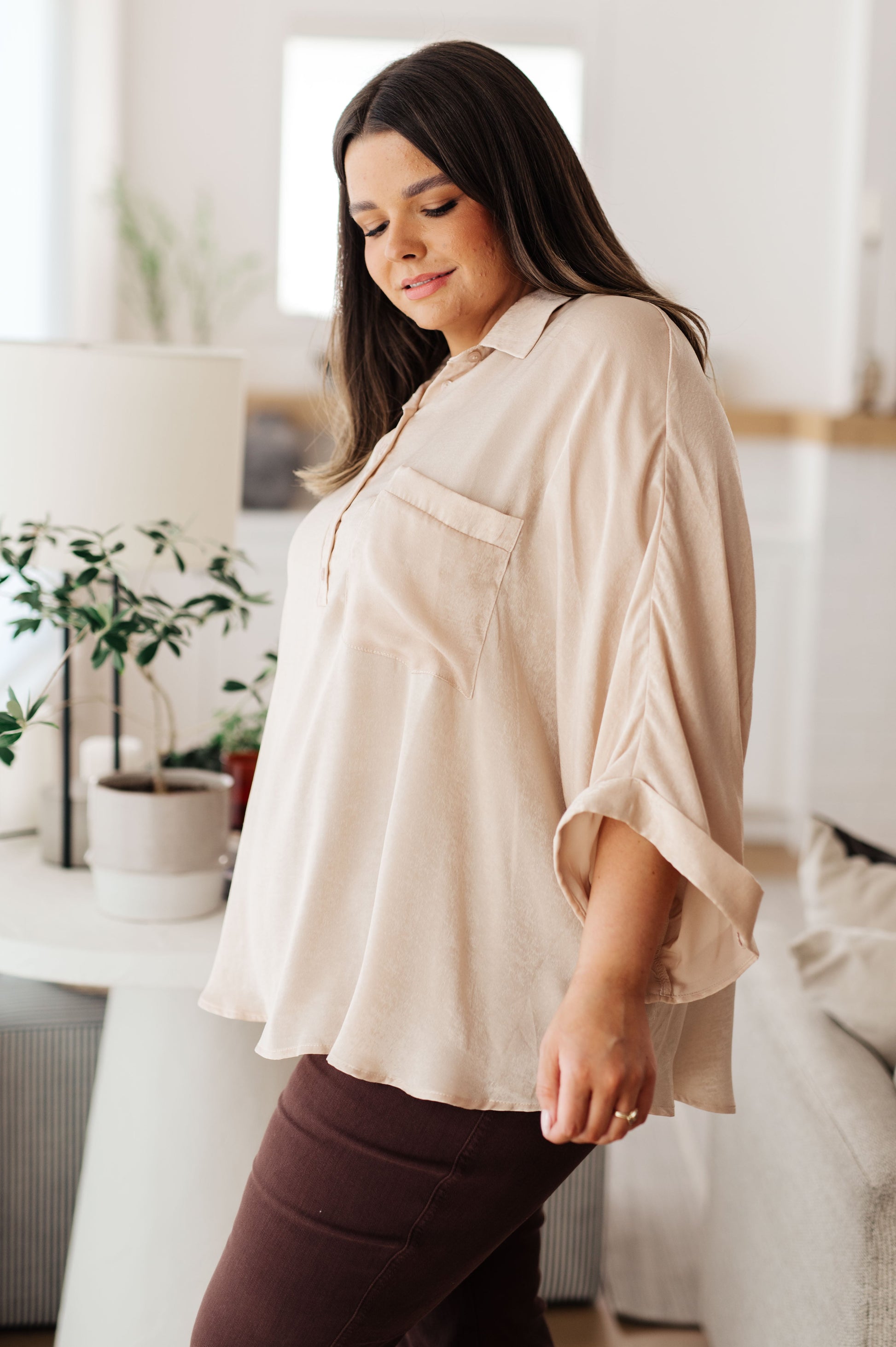 Champagne-colored poly satin top with a collared neckline, quarter-length button placket, oversized dolman sleeves with rolled cuffs, and a boxy, oversized fit.