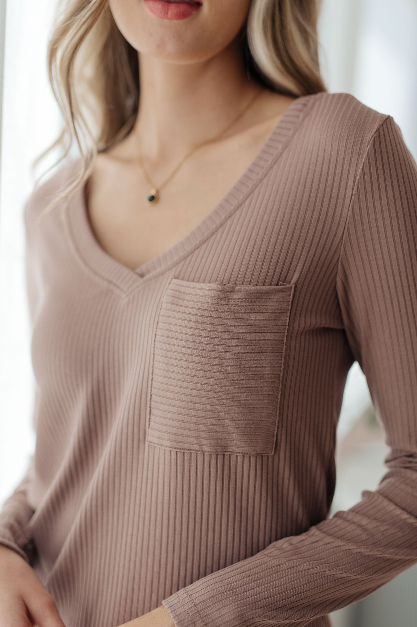 Close-up of Indie Long Sleeve V-Neck Top in Beige showing v-neck detail and patch pocket.