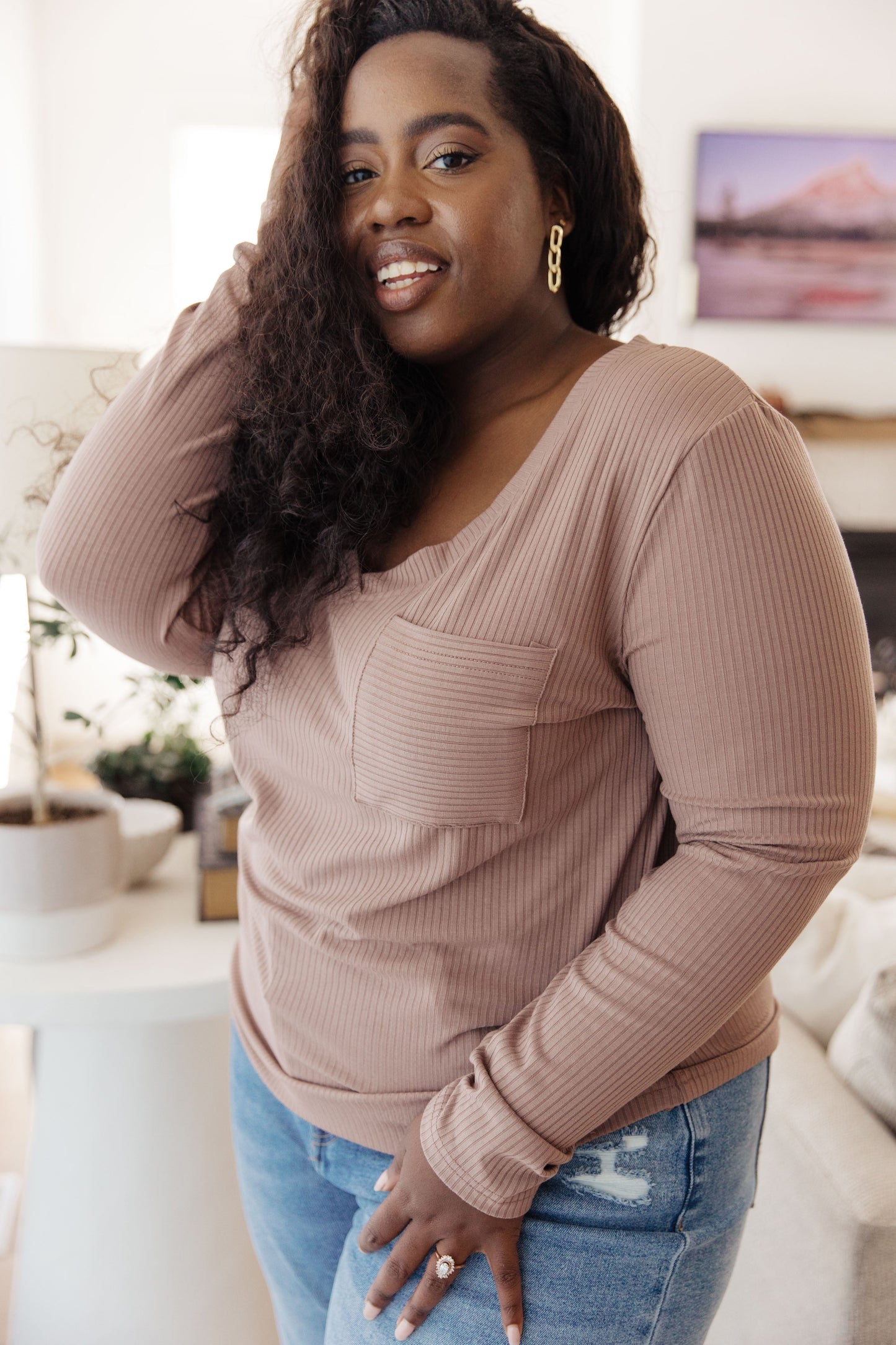 Plus size model wearing Indie Long Sleeve V-Neck Top in Beige with ribbed knit fabric.