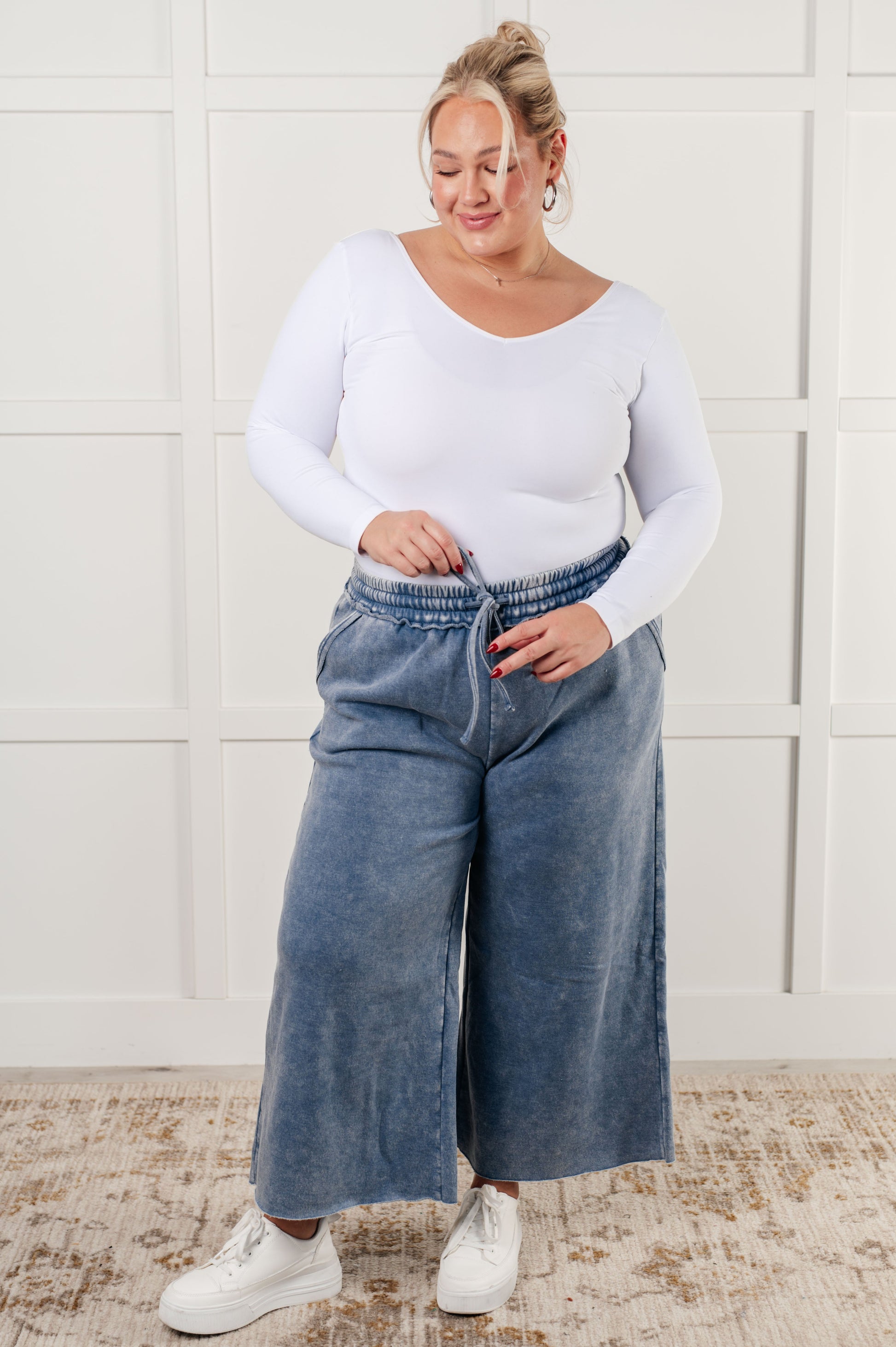 Indie Wide Leg Cropped Pants in soft fleece, featuring a trendy mineral wash in dusty blue. Designed with a drawstring elastic waist, functional side pockets, raw seam details, wide leg, and cropped length for a cozy, stylish, and relaxed look.