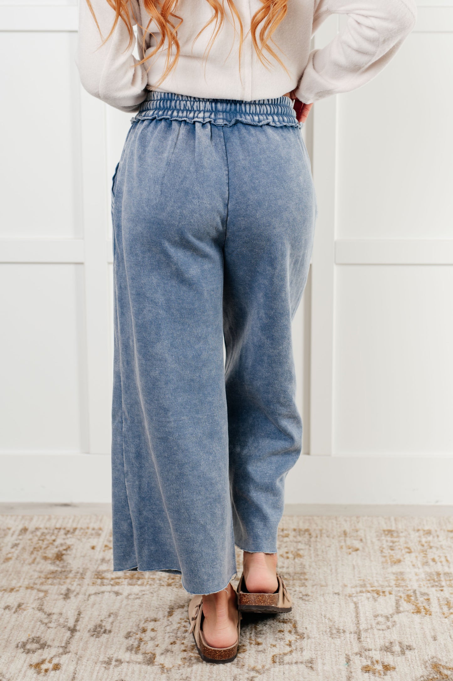 Indie Wide Leg Cropped Pants in soft fleece, featuring a trendy mineral wash in dusty blue. Designed with a drawstring elastic waist, functional side pockets, raw seam details, wide leg, and cropped length for a cozy, stylish, and relaxed look.