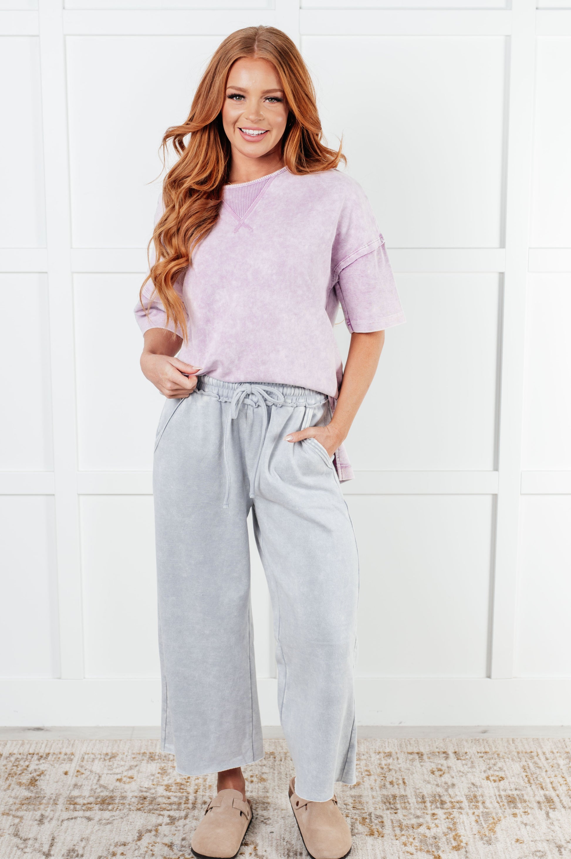 Indie Wide Leg Cropped Pants in soft fleece, featuring a trendy mineral wash in light gray. Designed with a drawstring elastic waist, functional side pockets, raw seam details, wide leg, and cropped length for a cozy, stylish, and relaxed look.