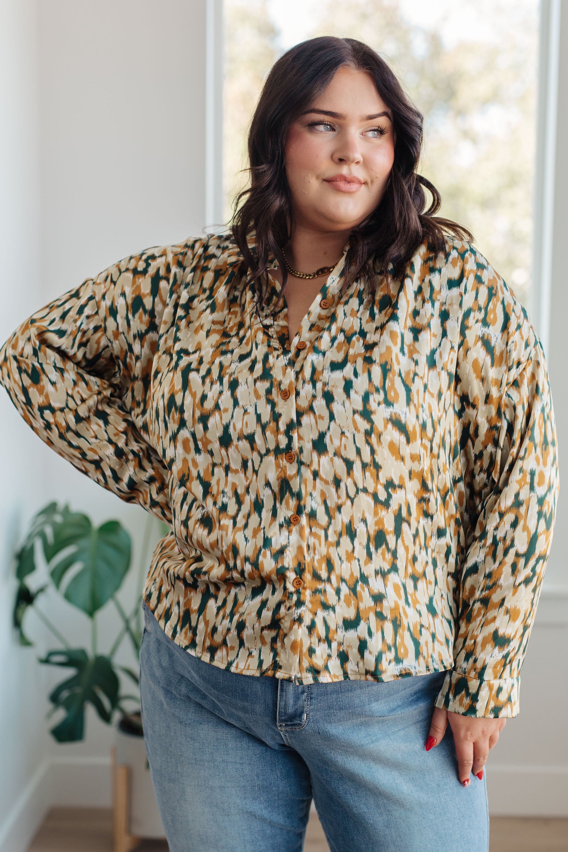 Mustard and tan abstract print blouse made from poly satin, featuring a collared neckline, button front fastening, and buttoned sleeve cuffs.