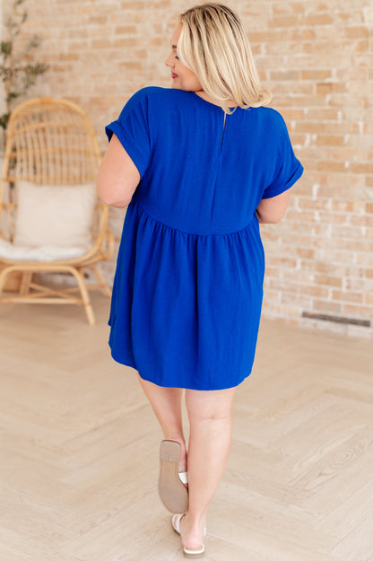 Plus size back view of Isa V-Neck Mini Dress in blue featuring gathered skirt and v keyhole closure.