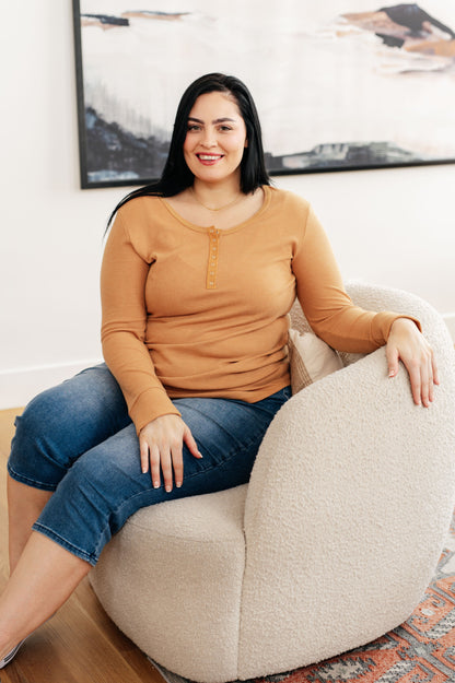 Golden sand-colored long henley top in soft waffle knit fabric, featuring a scoop neckline, banded hem, and snap-up closure.