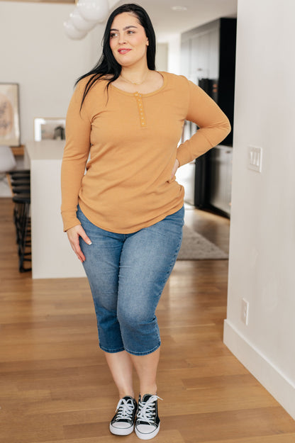 Golden sand-colored long henley top in soft waffle knit fabric, featuring a scoop neckline, banded hem, and snap-up closure.