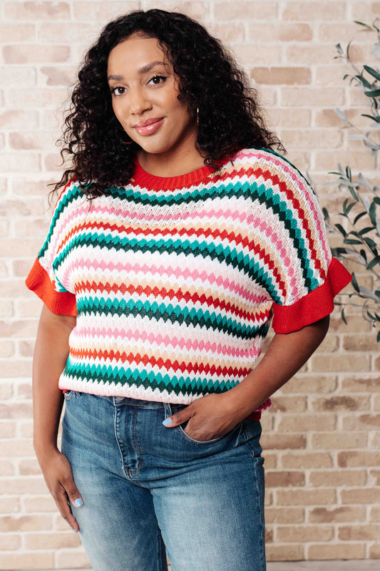 Plus size model front facing in Novalee striped knit top paired with jeans.