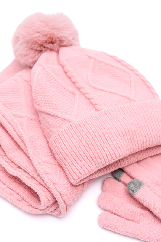 Flat lay of the Jane Frost pink knit beanie, scarf, and gloves arranged together.