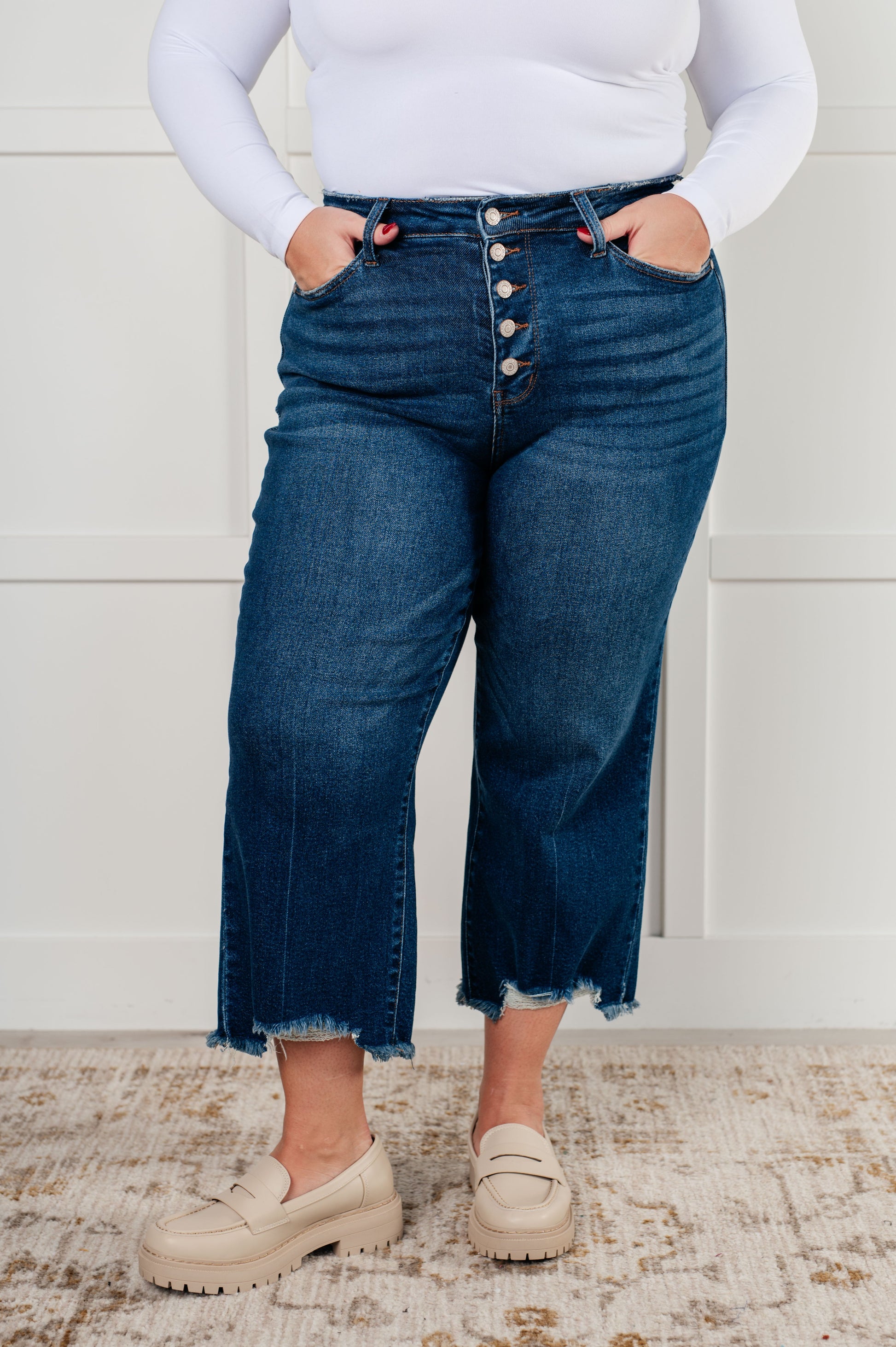 Plus size Janice High Rise Button Fly Wide Leg Crop Jeans by Judy Blue in a dark wash. Features a high-rise waist, button fly closure, wide leg crop silhouette, raw hem, and 4-way stretch for comfort and style. Perfect for a playful yet sophisticated look.