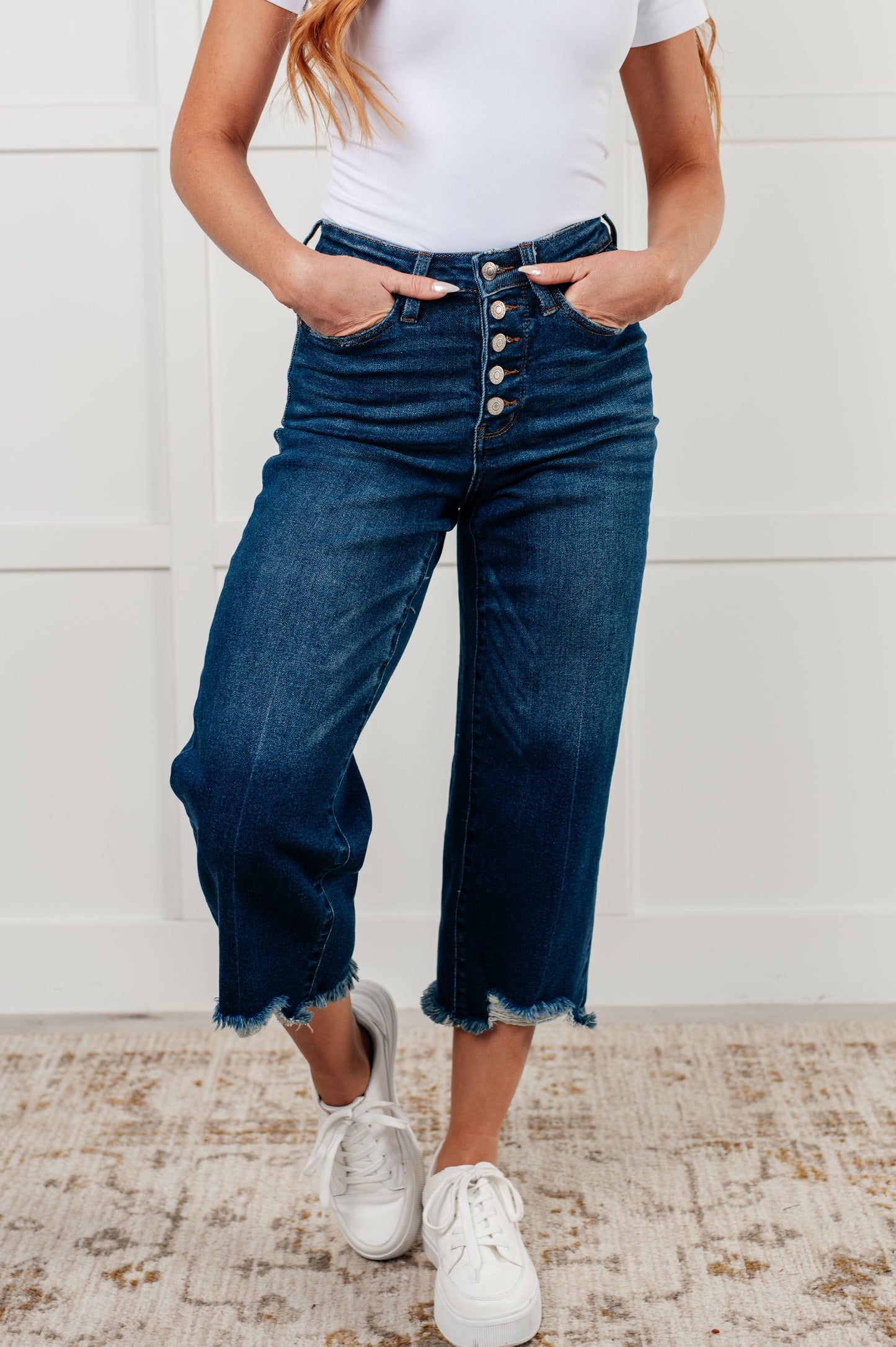 Janice High Rise Button Fly Wide Leg Crop Jeans by Judy Blue in a dark wash. Features a high-rise waist, button fly closure, wide leg crop silhouette, raw hem, and 4-way stretch for comfort and style. Perfect for a playful yet sophisticated look.