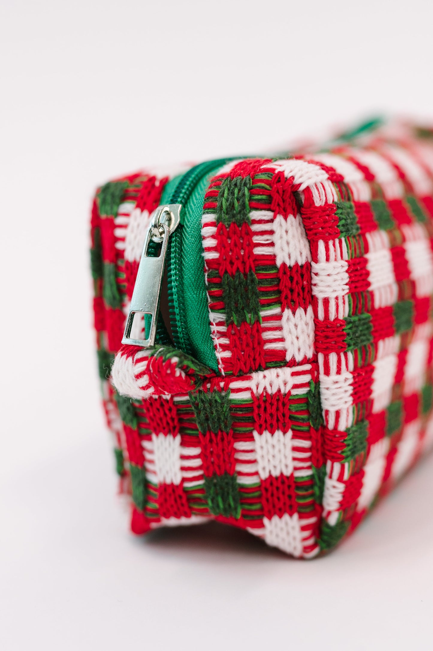 Close-up of Jolly Holiday Textured Woven Zip Bag showing green zipper and silver hardware.