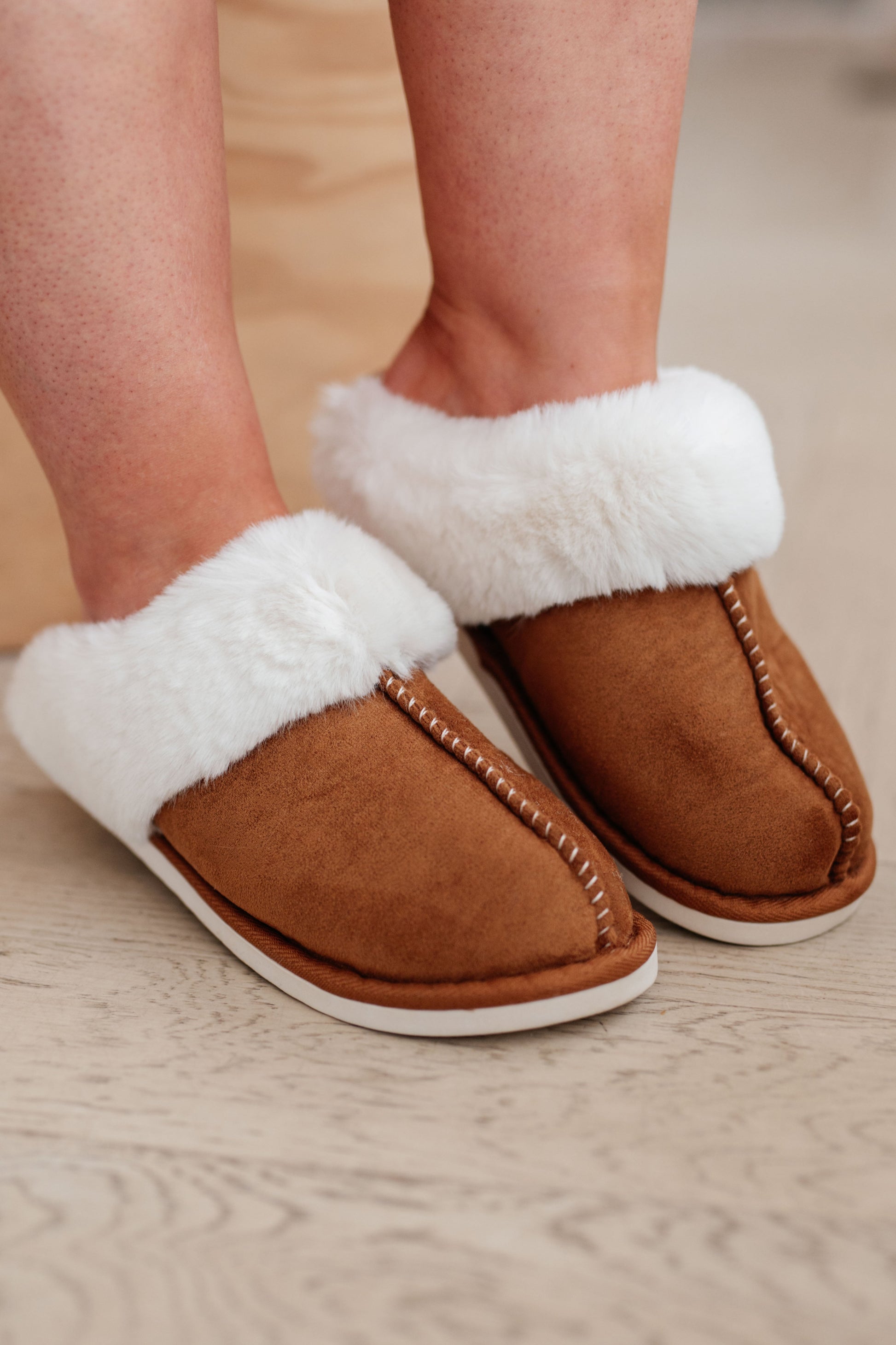 Brown faux fur and vegan leather mule-style slippers with a rubber sole for comfort.