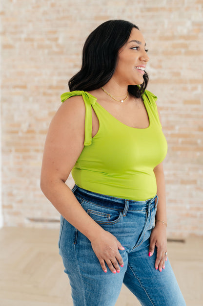 Plus size side view of Juska Bodysuit in lime green with adjustable straps, showing body-hugging fit and secure coverage.