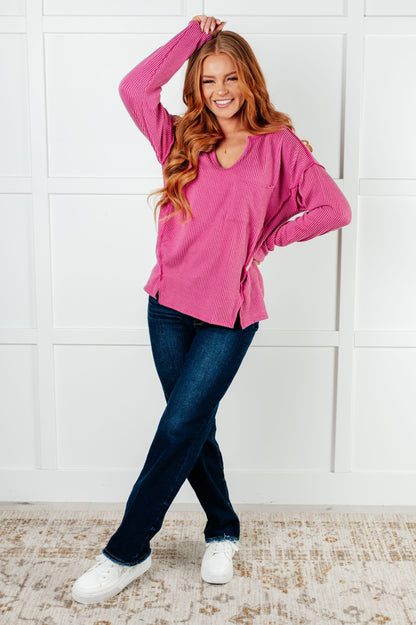 Model wearing magenta ribbed top, full body view with jeans