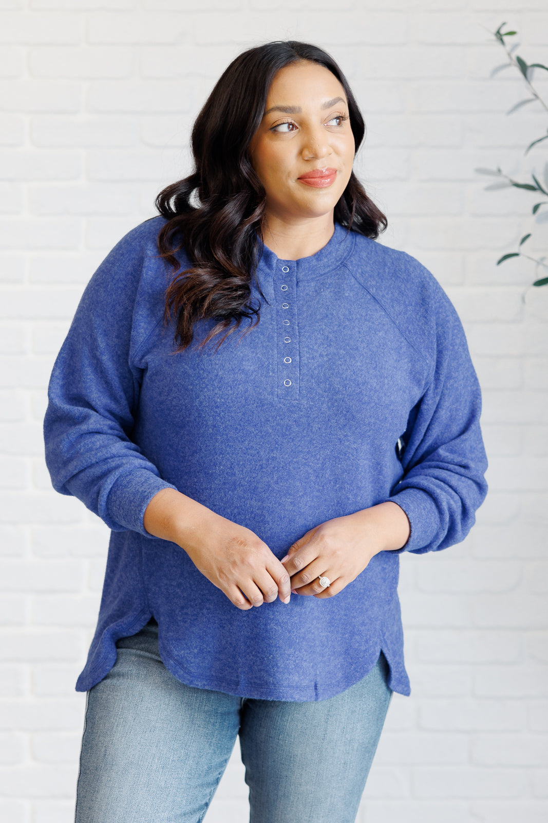 Bright blue long-sleeve tee made from soft melange hacci knit fabric. Features a round neckline with half-snap buttons, raglan sleeves, and banded cuffs.