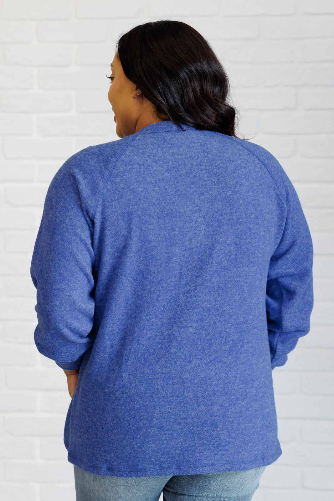 Bright blue long-sleeve tee made from soft melange hacci knit fabric. Features a round neckline with half-snap buttons, raglan sleeves, and banded cuffs.