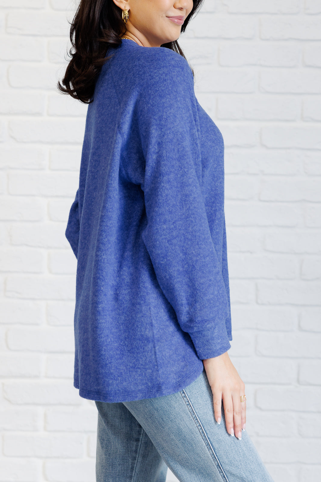 Bright blue long-sleeve tee made from soft melange hacci knit fabric. Features a round neckline with half-snap buttons, raglan sleeves, and banded cuffs.