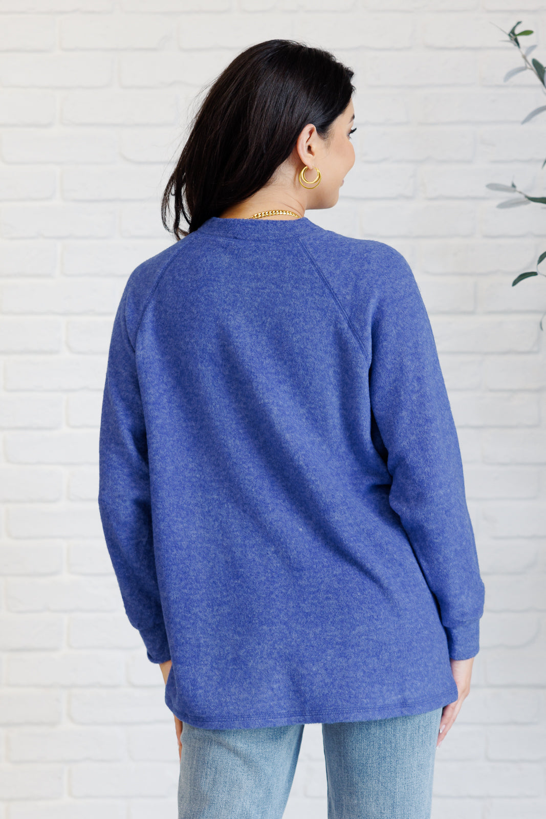 Bright blue long-sleeve tee made from soft melange hacci knit fabric. Features a round neckline with half-snap buttons, raglan sleeves, and banded cuffs.