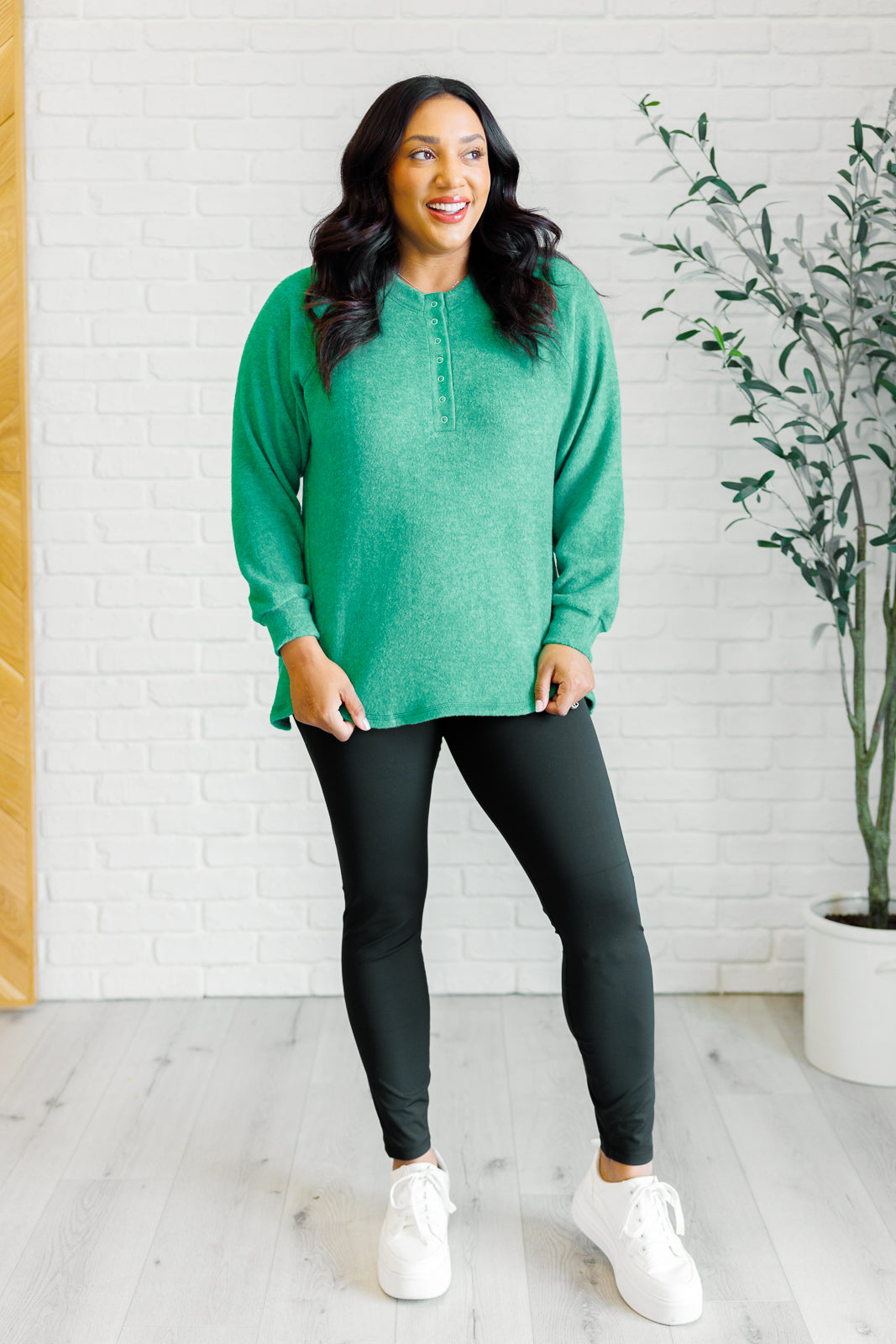 Forest green long-sleeve tee made from soft melange hacci knit fabric. Features a round neckline with half-snap buttons, raglan sleeves, and banded cuffs.