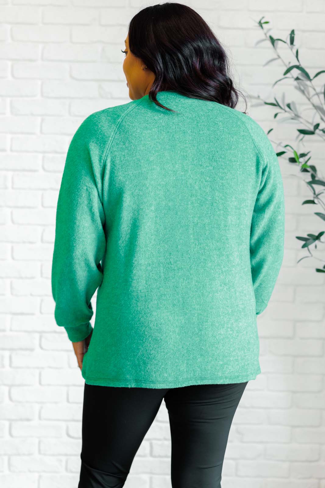 Forest green long-sleeve tee made from soft melange hacci knit fabric. Features a round neckline with half-snap buttons, raglan sleeves, and banded cuffs.