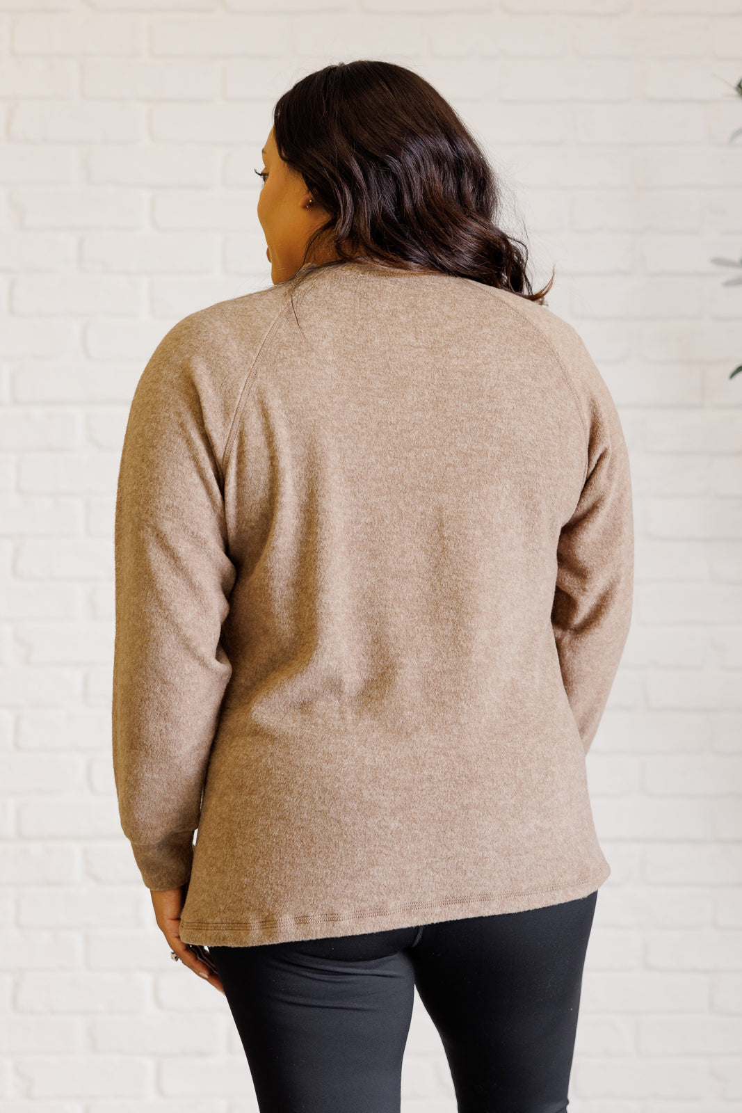 Mocha long-sleeve tee made from soft melange hacci knit fabric. Features a round neckline with half-snap buttons, raglan sleeves, and banded cuffs.