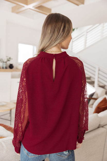 Back view of Lacey Blouse showing keyhole button closure and lace sleeve detail.