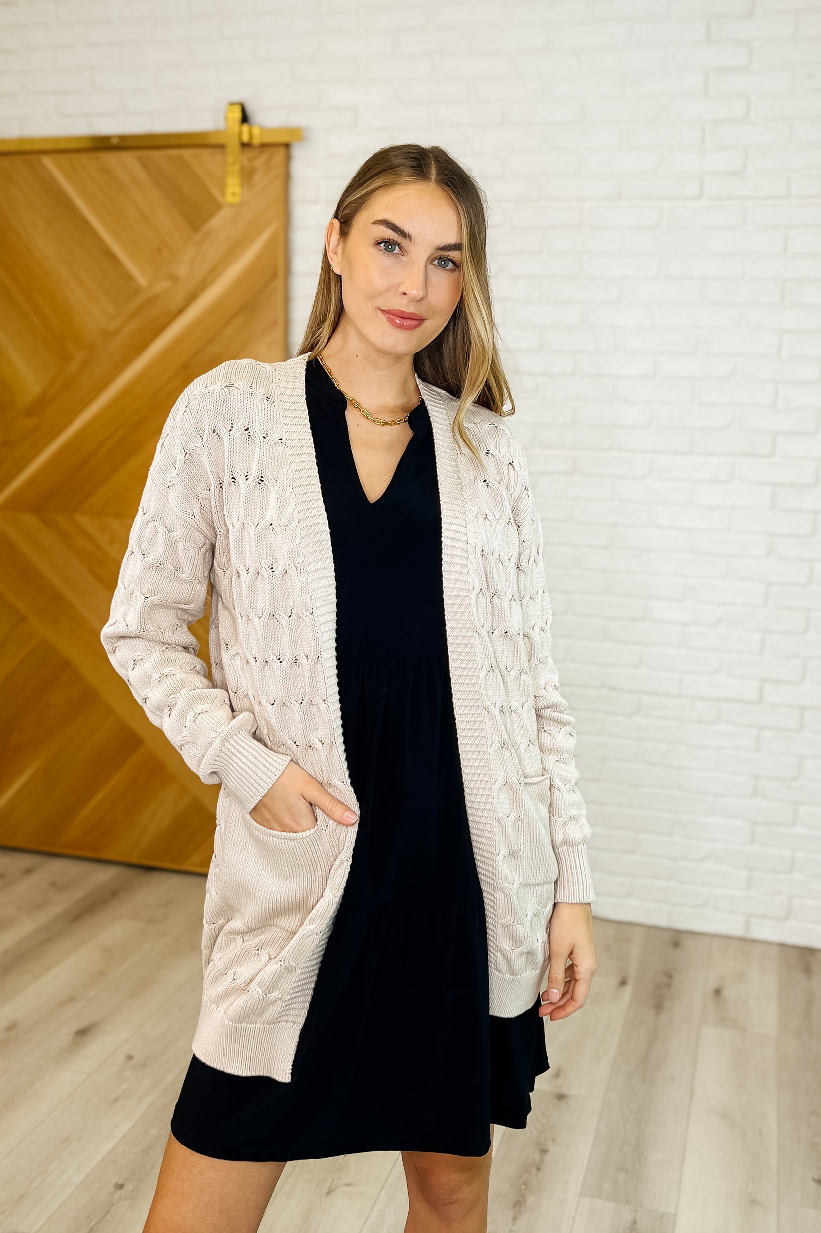 Laurell ivory cable knit open front cardigan with patch pockets and drop shoulder sleeves.