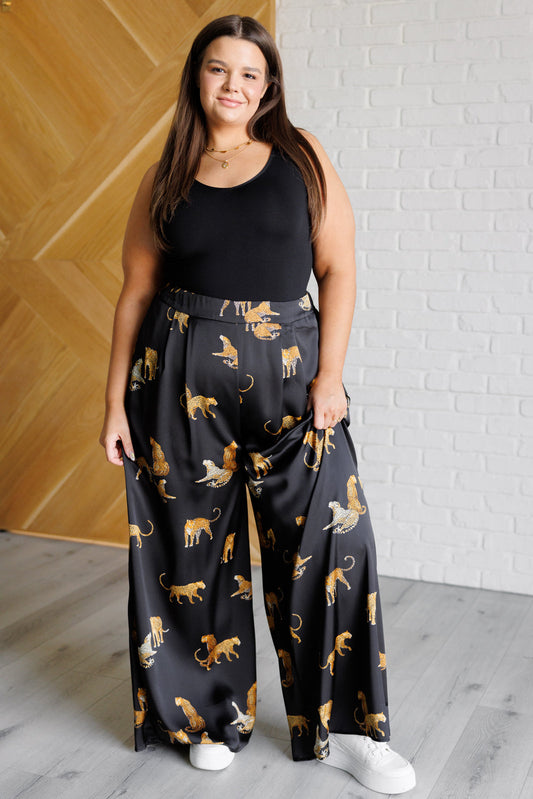 Plus size model wearing Leandra Leopard Satin Wide Leg Pants high rise flowy pants.