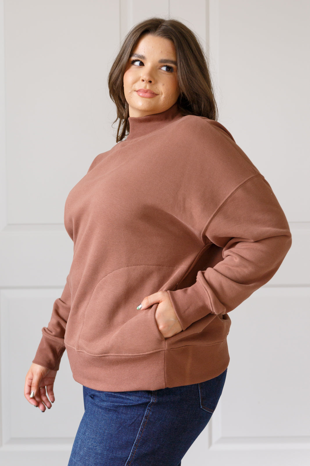 Soft cocoa sweatshirt fleece pullover with a ribbed mock neckline, long sleeves, dropped shoulders, side pockets, and a relaxed fit.