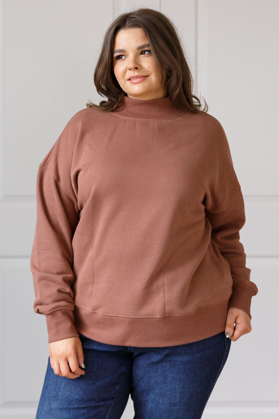 Soft cocoa sweatshirt fleece pullover with a ribbed mock neckline, long sleeves, dropped shoulders, side pockets, and a relaxed fit.