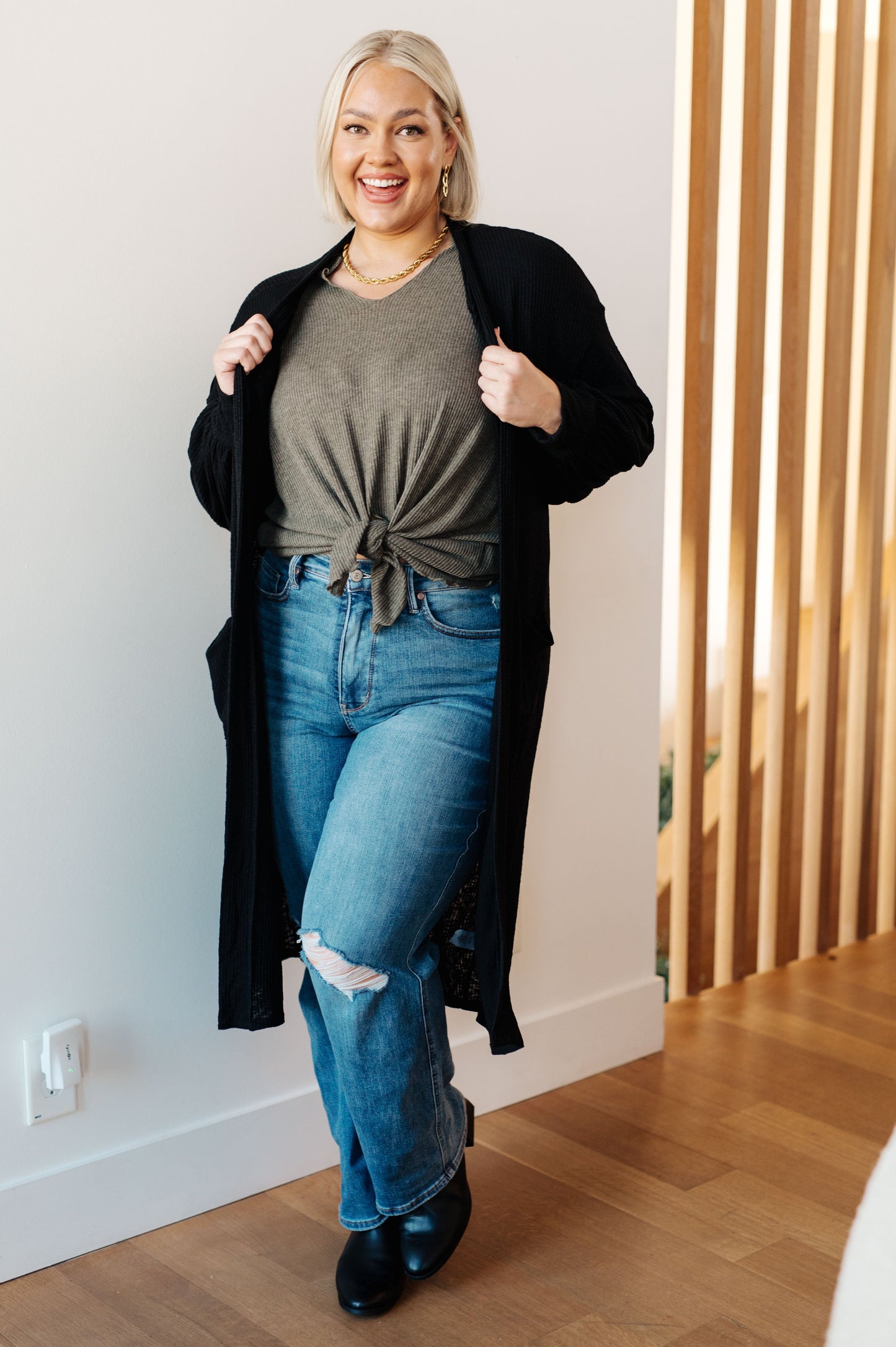 Plus size model wearing Lee Duster Cardigan in Black with long balloon sleeves and open front.