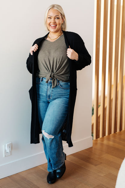 Plus size model wearing Lee Duster Cardigan in Black with long balloon sleeves and open front.