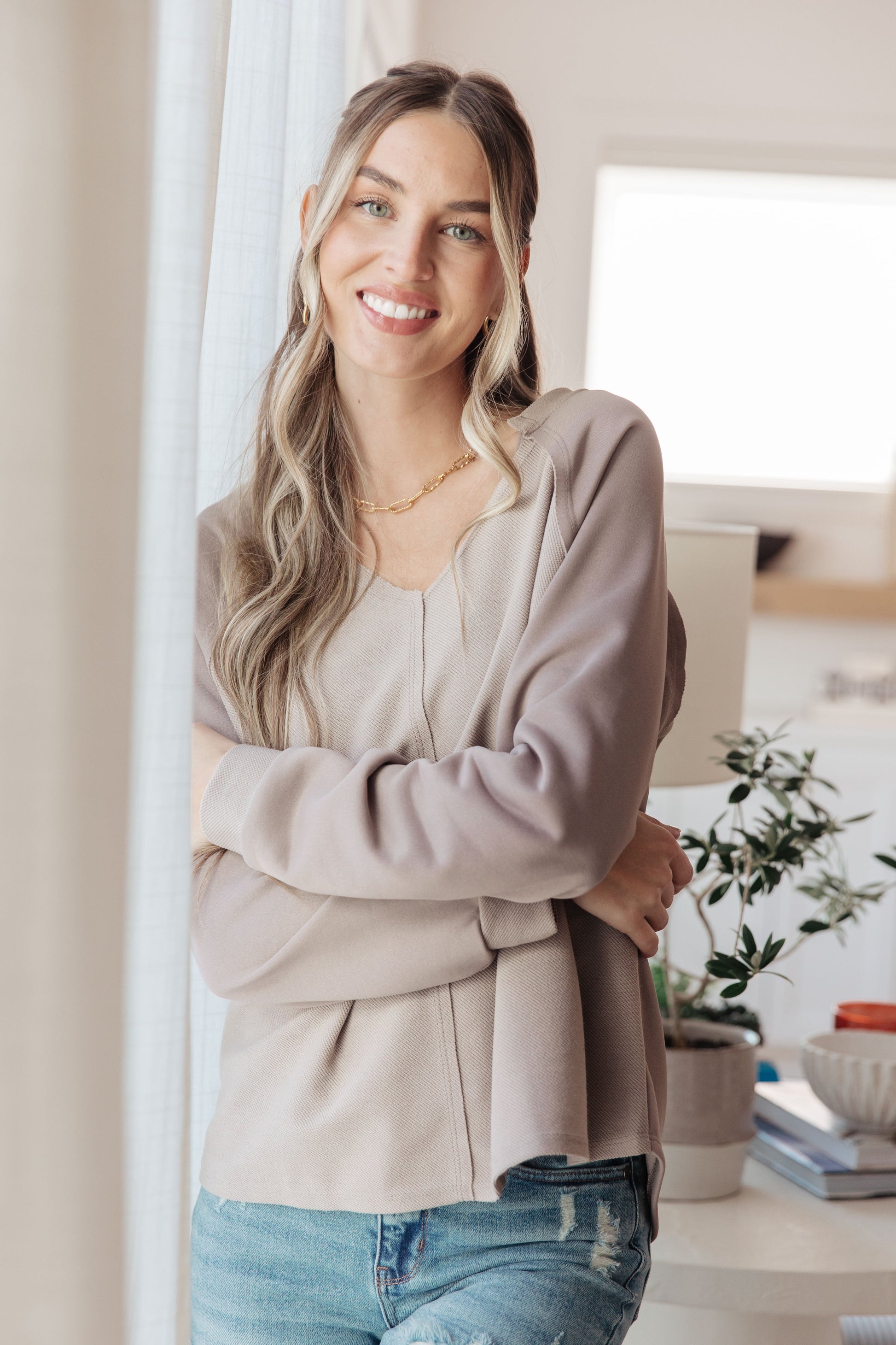 Model wearing Dominique V-Neck Top, textured knit with notched neckline and raglan sleeves
