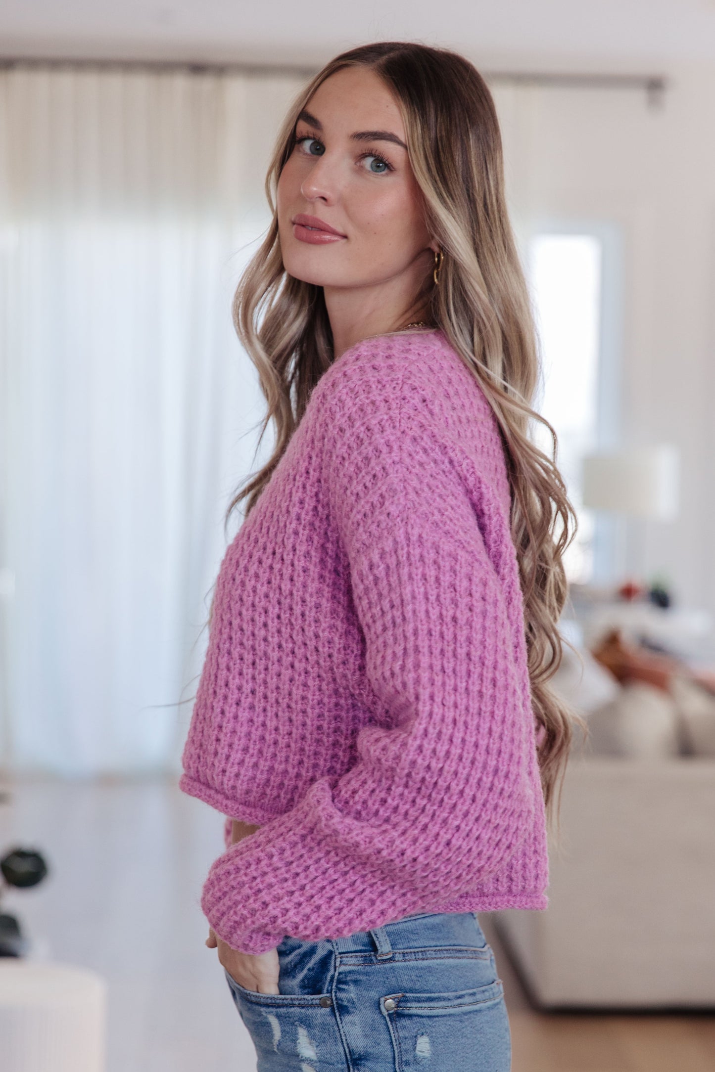 Side angle of Leticia Sweater highlighting rolled stepped hem and side slits.