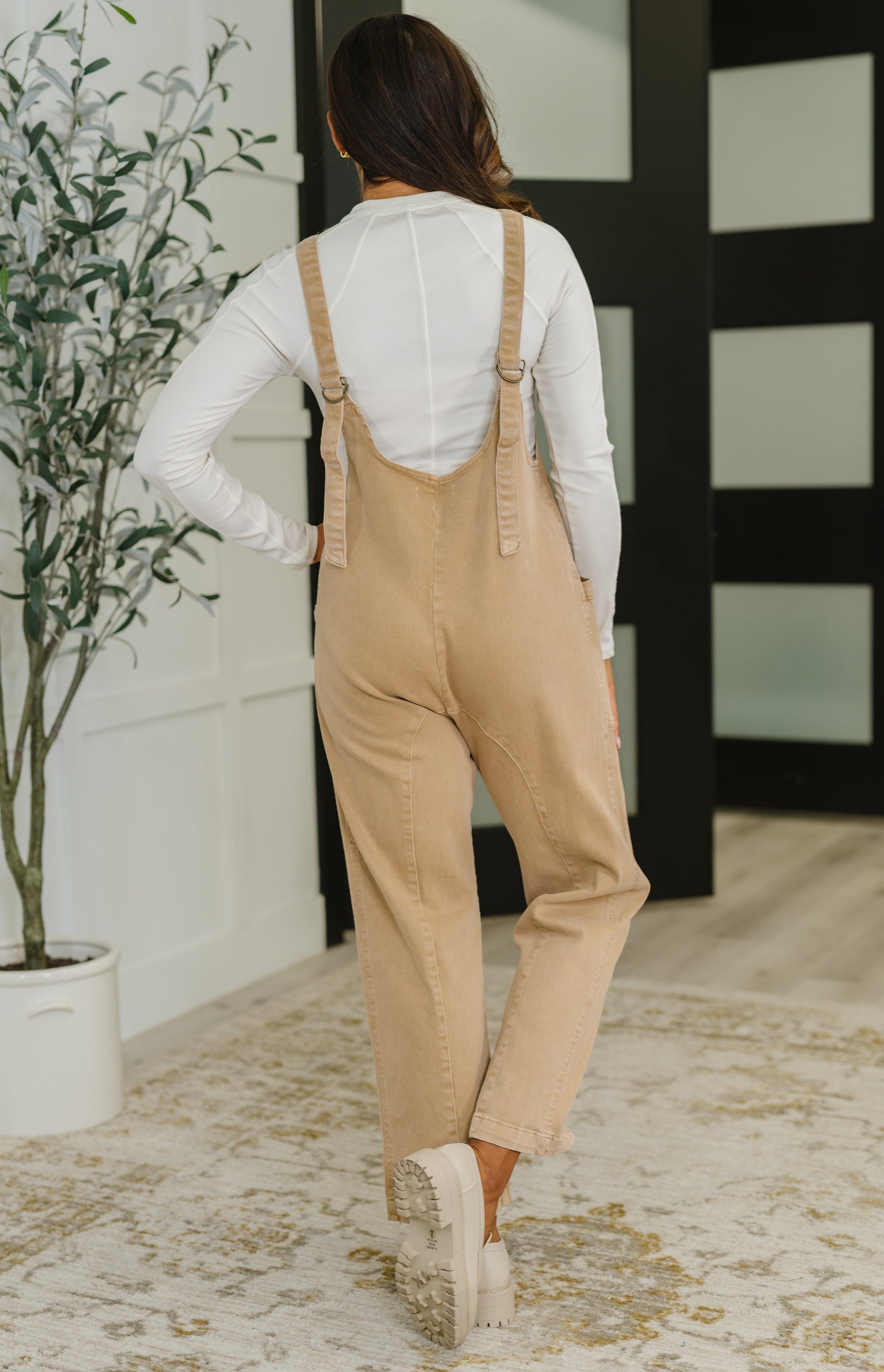 Back view of Litzy Jumpsuit in Brush with adjustable straps, bronze accents, and relaxed fit.