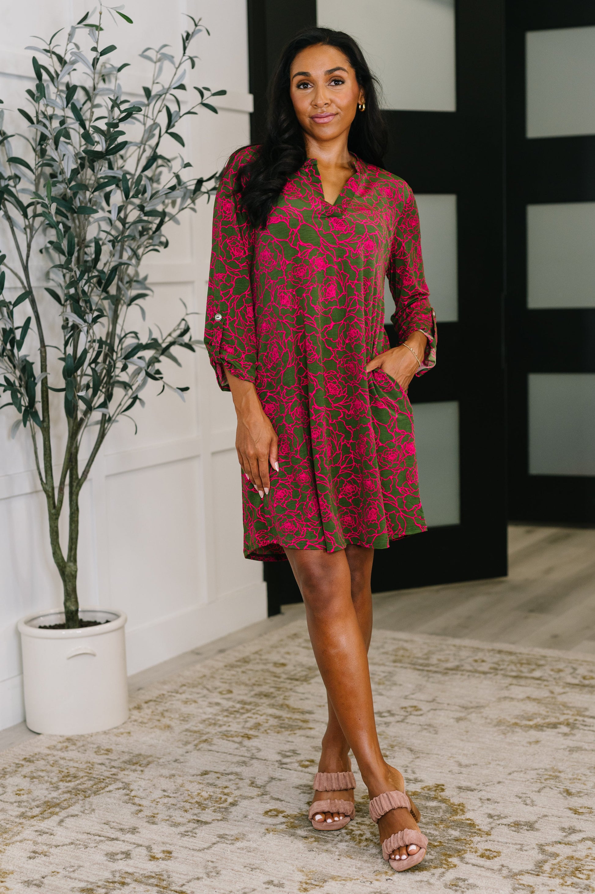 Woman wearing Lizzy Long Sleeve Dress in pink and olive floral print with ¾ sleeves and sandals.