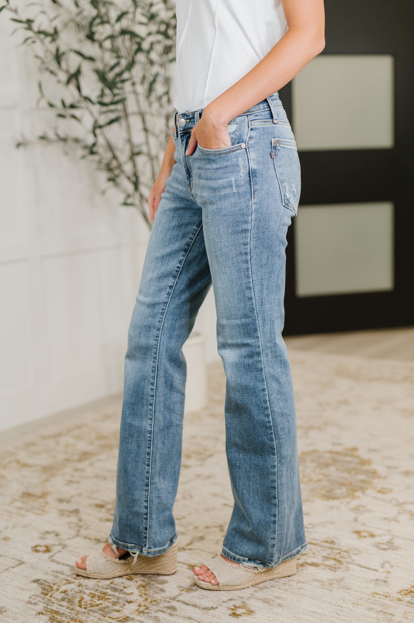 Side view of Lorena Bootcut Jeans by Judy Blue with bootcut fit, mid rise waist, and vintage wash distressed finish.