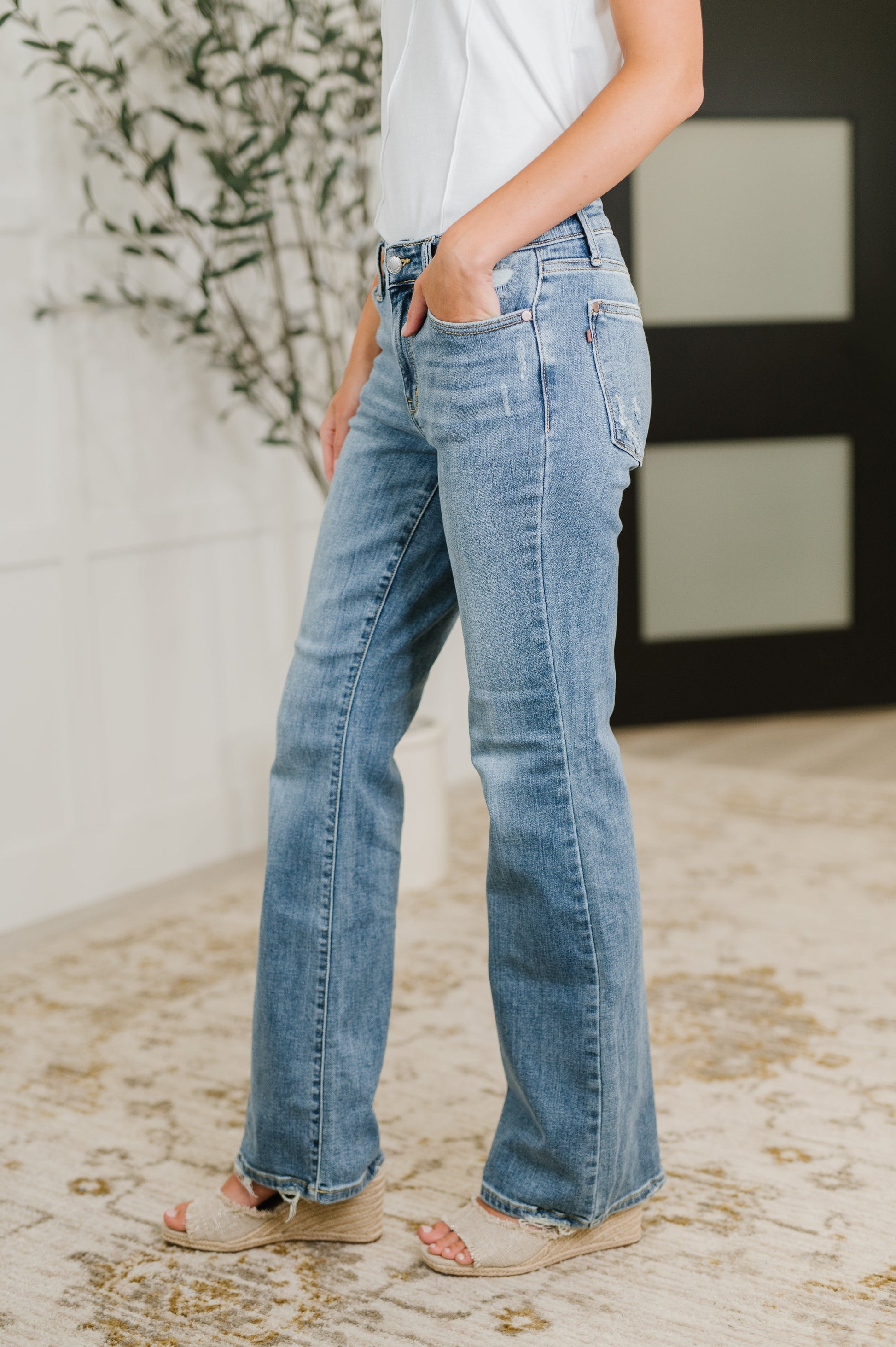 Side view of Lorena Bootcut Jeans by Judy Blue with bootcut fit, mid rise waist, and vintage wash distressed finish.
