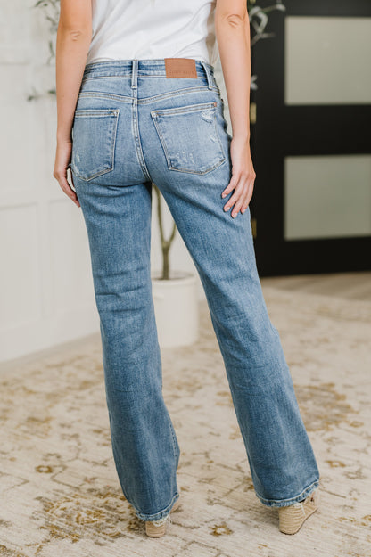Back view of Lorena Bootcut Jeans in vintage wash featuring mid rise waist, bootcut silhouette, and distressed hem.