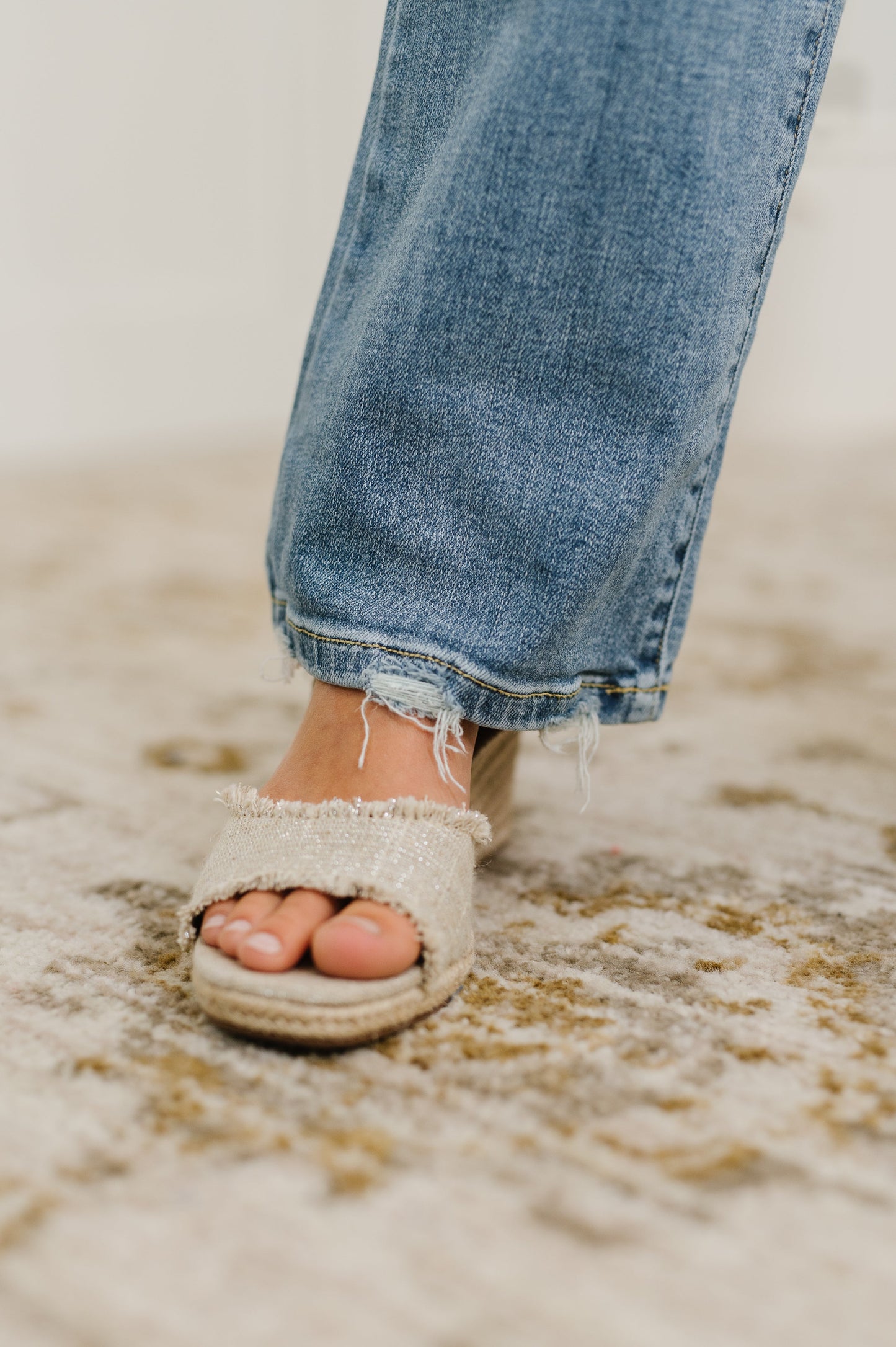 Close up of Lorena Bootcut Jeans highlighting raw distressed hem in vintage wash denim.