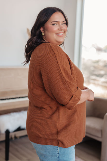 Side profile of plus size model in Zizi Rust Sweater Top, boat neckline and dolman sleeve detail