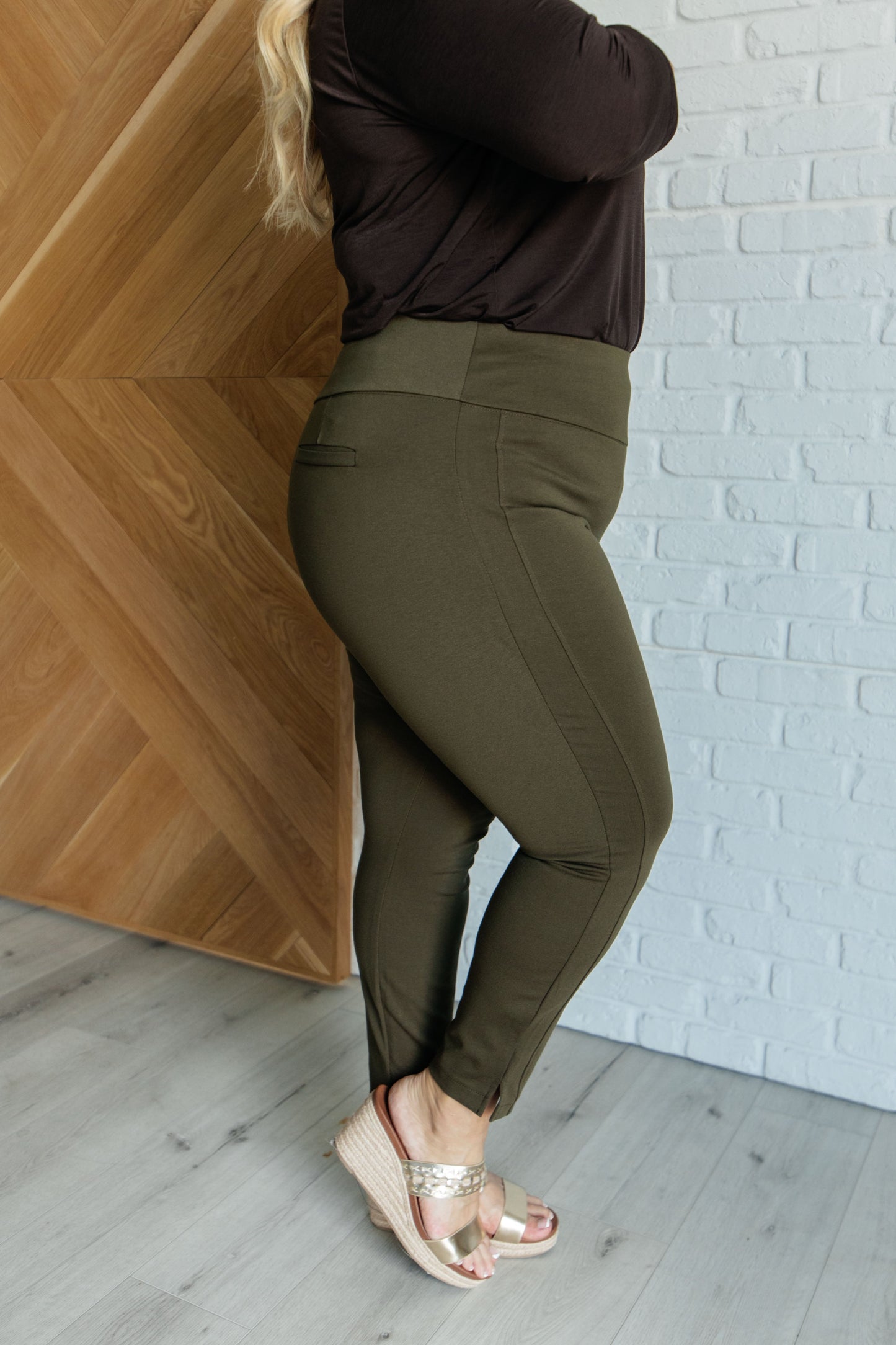 Skinny Pants in olive, high-rise, slim-fit, made from ponte knit fabric. Pull-on style with tuxedo stripe, faux welt pockets, and cuff slit. Ankle crop design for a chic, flattering look