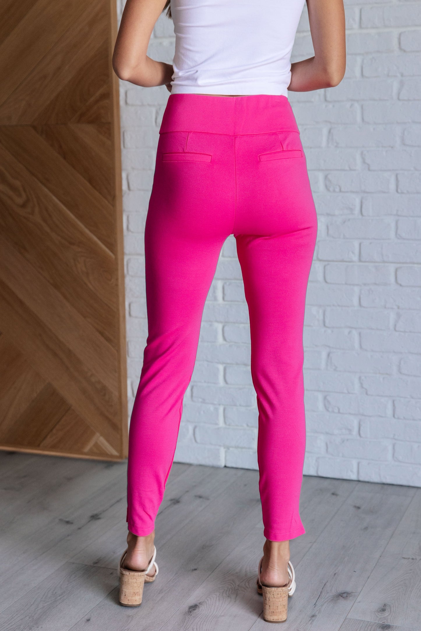 Skinny Pants in hot pink with high-rise, slim fit, and ponte knit fabric. Features tuxedo stripes, faux welt pockets, and an elastic waistband.